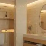 Nowoczesna łazienka 2026 w ciepłych beżach z matowymi płytkami, szczotkowaną armaturą i organicznym lustrem