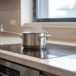 Niewidoczna indukcja pod blatem kuchennym ze spieku kwarcowego – system gotowania bez widocznej płyty